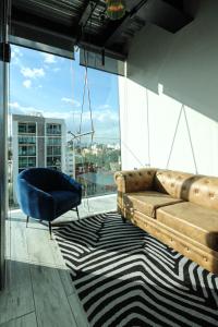 a living room with a couch and a chair on a balcony at Hermoso y cómodo mini LOFT 3 in Mexico City