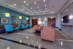 un vestíbulo con una sala de espera con sillas azules y naranjas en Drury Inn & Suites Gainesville en Gainesville