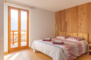 a bedroom with a bed and a large window at La Maison de Catherine in Puy-Saint-Pierre