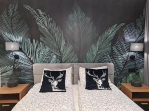 sypialnia z łóżkiem z obrazem jelenia głowy w obiekcie Rezydencja Green Hill - ekskluzywny dom w Karpaczu w mieście Karpacz