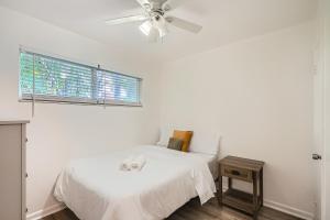 um quarto branco com uma cama e uma ventoinha de tecto em Tropical Retreat ** 2 BR ** Singer Island em West Palm Beach