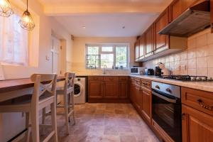 a kitchen with wooden cabinets and a stove top oven at Springfield Place - 3 Bed Central Reading - Sleeps 6 - Free Parking in Reading