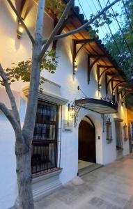 un edificio con un albero davanti ad una porta di Hotel Del Virrey a Salta