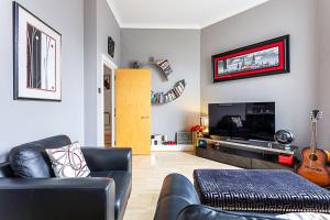 a living room with a couch and a television at Chic Farringdon Flat in London
