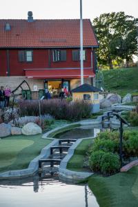 einen Golfplatz mit einem Teich vor einem Haus in der Unterkunft Bergs Slussar Vandrarhem & Stugor in Vreta Kloster