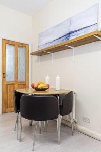 a table with chairs in a room with aoir at Studio Flat 3, 20 mins to Central London in The Hyde