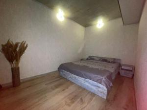 a bedroom with a bed and two lights on the wall at Vato Home in Tbilisi City