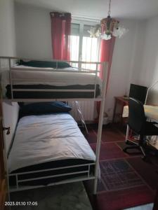 2 stapelbedden in een kamer met een bureau bij Habitación privada, luminosa y bien comunicada in Madrid