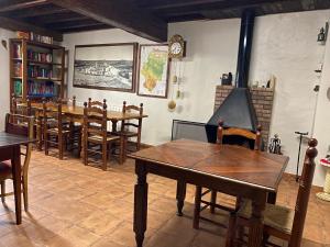 Un comedor con una mesa y sillas y un reloj. en Casa Sara, en Cantavieja