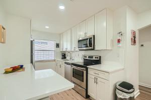 a kitchen with white cabinets and a stove top oven at Hidden Oasis ** Stunning 2 BR ** Sunset Shores in West Palm Beach