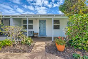 a white house with a blue door and some plants at Hidden Oasis ** Stunning 2 BR ** Sunset Shores in West Palm Beach