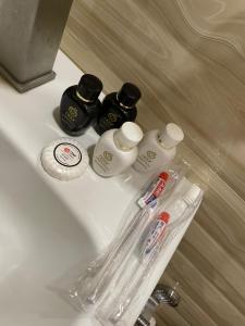 ein Waschbecken mit 3 Flaschen Zahnpasta und Zahnbürste in der Unterkunft Glendale Boutique Hotel in Yerevan