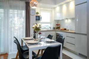 a kitchen with a white table with chairs and a white table and chairsktop at Apartment Mare Blu in Kožino