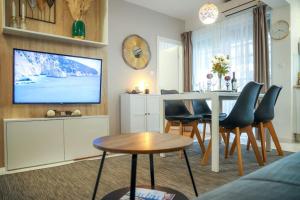 a living room with a dining table and a tv at Apartment Mare Blu in Kožino