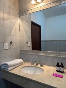 baño con lavabo y espejo grande en Hotel Del Virrey en Salta