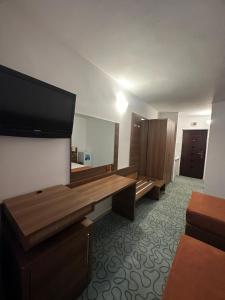 a hotel room with a large mirror and a desk at Garsoniere Aby in Turnu Măgurele