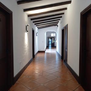 pasillo en un edificio con paredes blancas y suelo de baldosa en Hotel Del Virrey en Salta