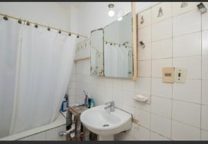 Baño blanco con lavabo y espejo en Georgy house, en Punta del Este