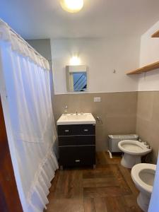 y baño con lavabo y aseo. en Casita Santa Ana Miramar Buenos Aires en Miramar