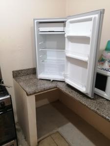 a white refrigerator with its door open in a kitchen at Dulce Hogar in Loja
