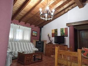 een woonkamer met een bank en een tv bij Casas Rurales Majana in Riópar