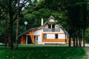 a small house with a gambrel roof in a yard at Good House in Vlăhiţa