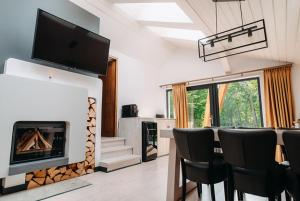 a living room with a fireplace and a table and chairs at Good House in Vlăhiţa