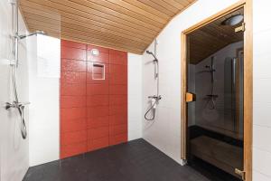 łazienka z prysznicem wyłożona czerwonymi kafelkami w obiekcie Napoli Residence 169m2 w mieście Tampere