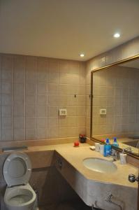 a bathroom with a sink and a toilet and a mirror at GK Apartment Delight in Bat Yam