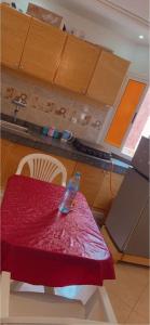 a table in a kitchen with a red table cloth at Chahrazad Hotspot -Balcony-Washing Machine -Kitchen in Saïdia