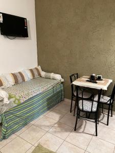 Habitación con cama y mesa con sillas. en Departamentos carlos paz en Villa Carlos Paz