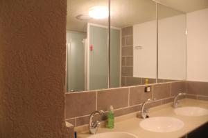 a bathroom with two sinks and a large mirror at Al Yakhour Hostel in Haifa +47 photos