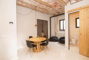 una sala da pranzo con tavolo e sedie in legno di Bonito apartamento en el Barri Vell Girona a Girona