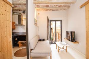 un soggiorno con divano e tavolo di Bonito apartamento en el Barri Vell Girona a Girona