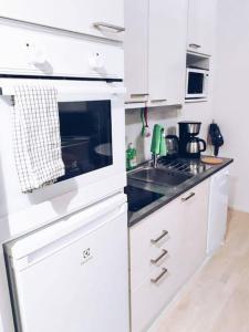 een witte keuken met een fornuis en een wastafel bij New Studio Zebra near Airport in Vantaa