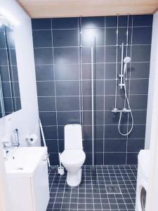 een blauwe betegelde badkamer met een toilet en een douche bij New Studio Zebra near Airport in Vantaa