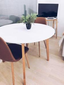 uma mesa branca com uma planta em cima em New Studio Zebra near Airport em Vantaa