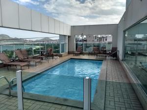 a swimming pool on top of a building at Condomínio Bristol Praia do Canto Apart Hotel in Vitória