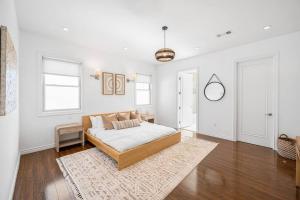 a white bedroom with a bed and a rug at Stunning TH #5 in Los Angeles
