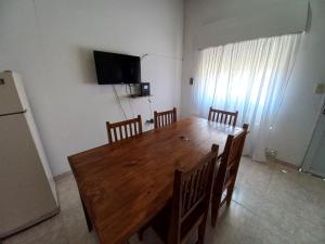 uma mesa de jantar com cadeiras e uma televisão na parede em Alojamientos Litoral - Casa del Sol em Gualeguaychú