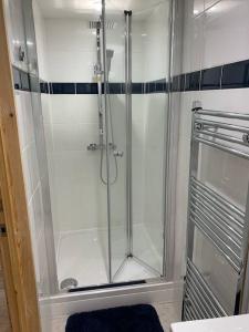 a shower with a glass door in a bathroom at Cornwall - Unique two storey barn in St Austell