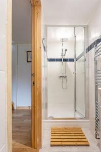 a bathroom with a shower with a glass door at Cornwall - Unique two storey barn in St Austell