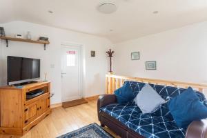 a living room with a couch and a tv at Cornwall - Unique two storey barn in St Austell