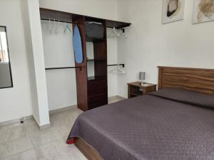 a bedroom with a bed and a dresser at Hermoso condominio con alberca en Puerto Morelos in Puerto Morelos