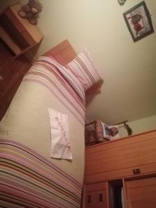 Una cama con una manta rosa y blanca. en Sam Bott, en Chambon-sur-Voueize