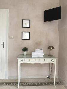 een wit bureau met een televisie aan de muur bij B&B Aquilone in Urbino