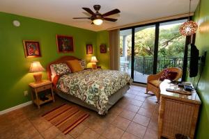 een slaapkamer met groene muren, een bed en een raam bij Leaward Isle Island Retreat in Key West