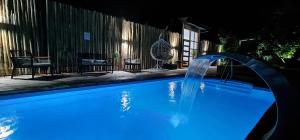 a blue swimming pool with a water fountain at Borde Luz Hotel Boutique in Pucón