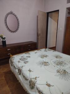 1 dormitorio con cama y espejo en Chalet los Abuelos en La Falda