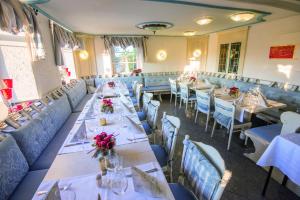 a dining room with tables and chairs with flowers on them at Hotel & Restaurant Zum Vater Rhein in Monheim